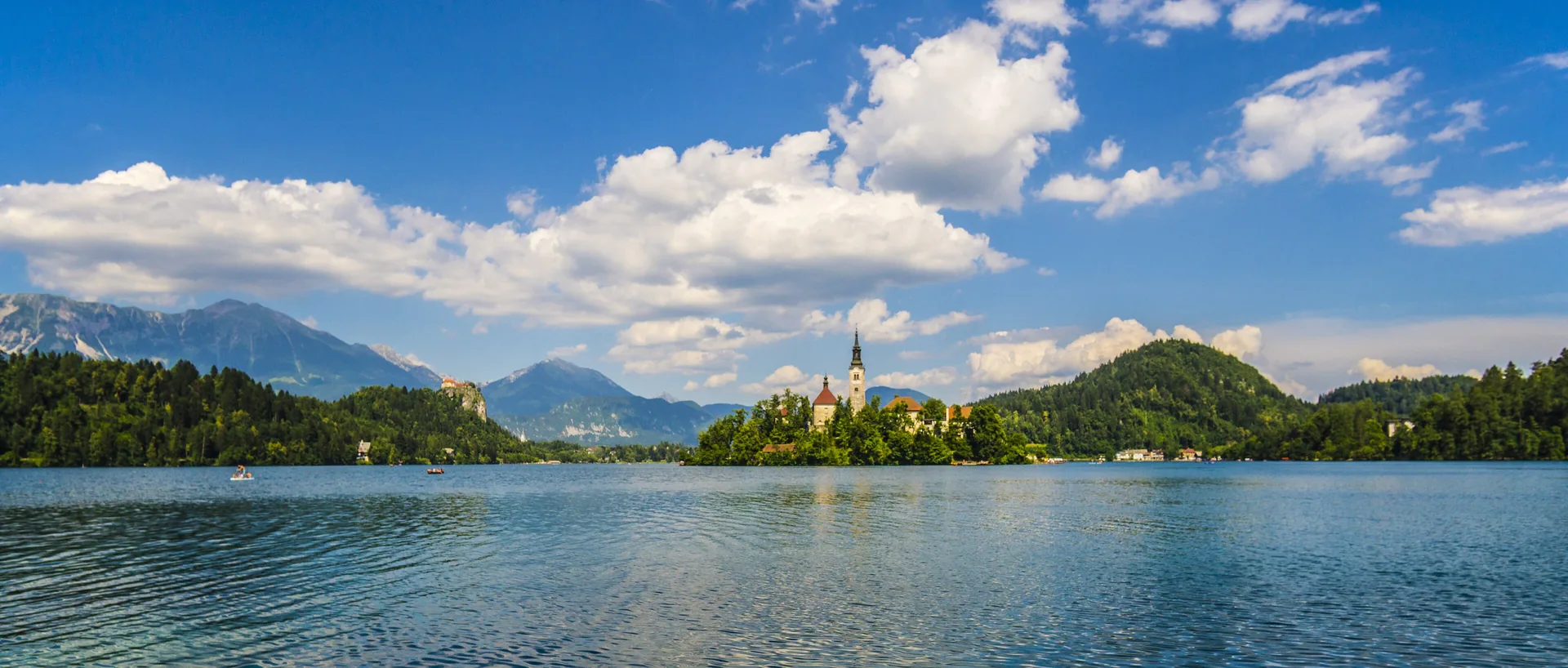 Lake Bled from the water, the island church at its centre and mountains beyond
