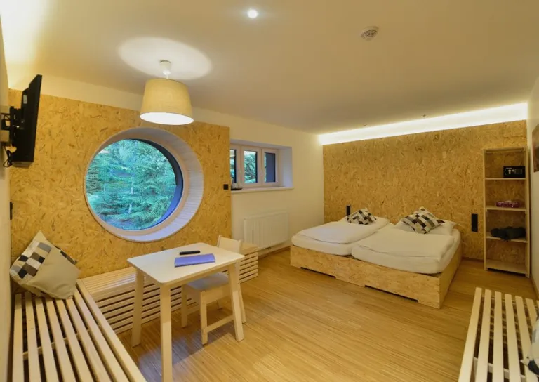 A Montanie Resort room, timber-lined with a round window onto the forest